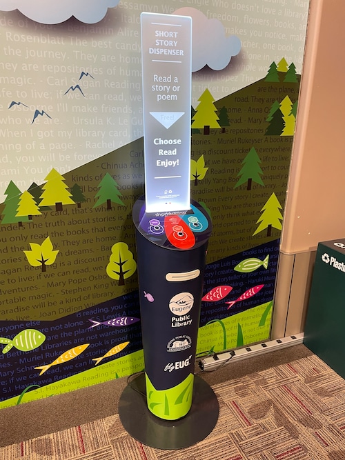 The short story dispenser is a cylinder-shaped machine with a sign on top inviting people to read a story or poem, choose, read, enjoy