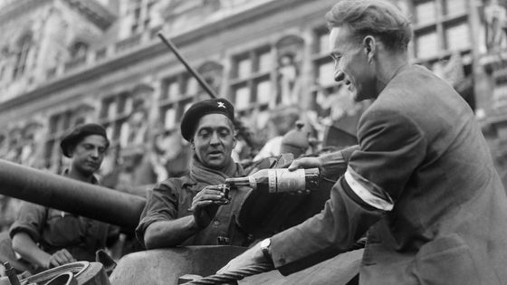 Un membre des FFI offre un verre à un soldat de la 2ème division blindée devant la Mairie de Paris le 24 août 1944 durant la Libération de Paris.