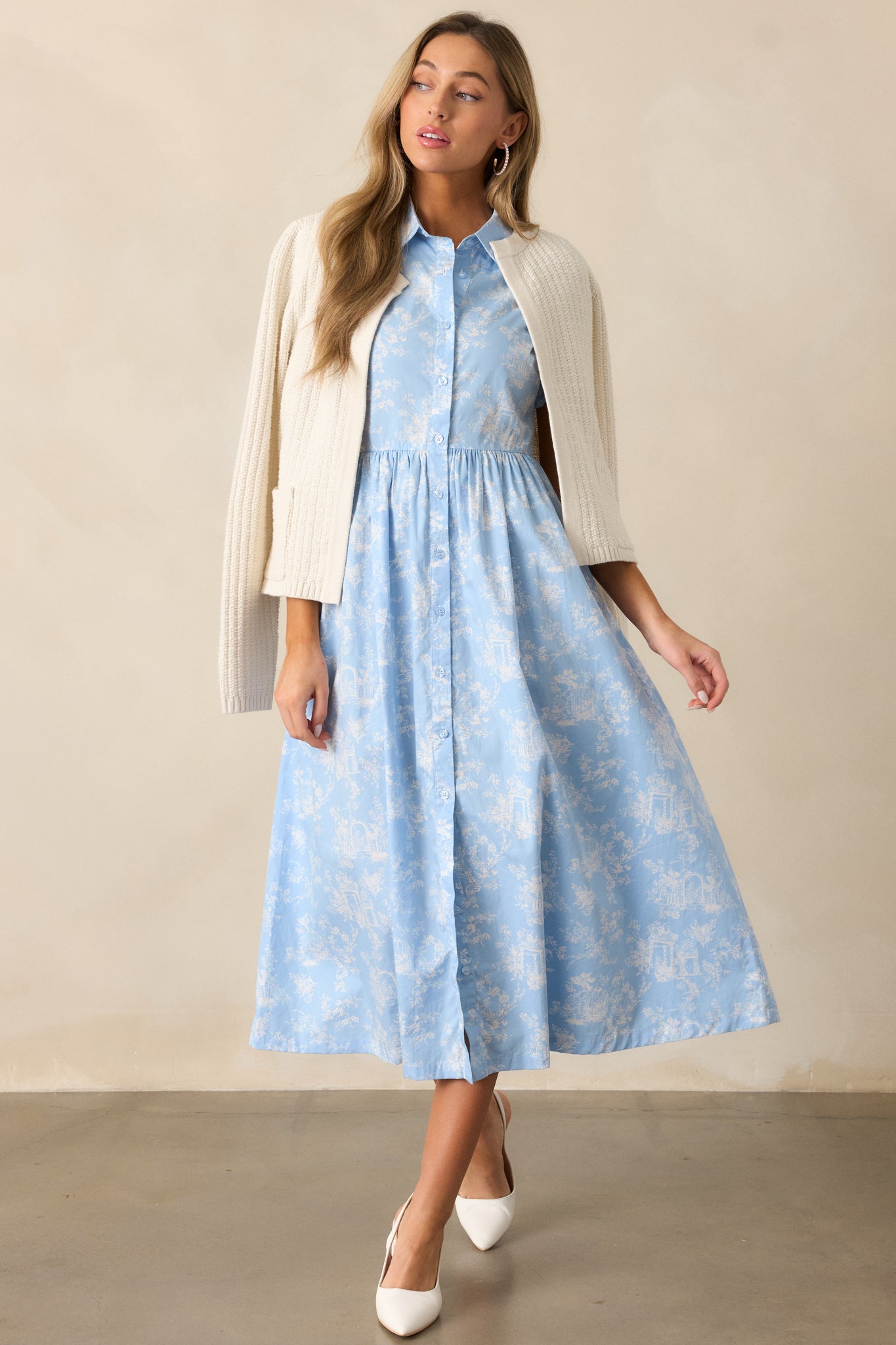 A light blue maxi dress highlighting the collared neckline and intricate toile pattern throughout the fabric.