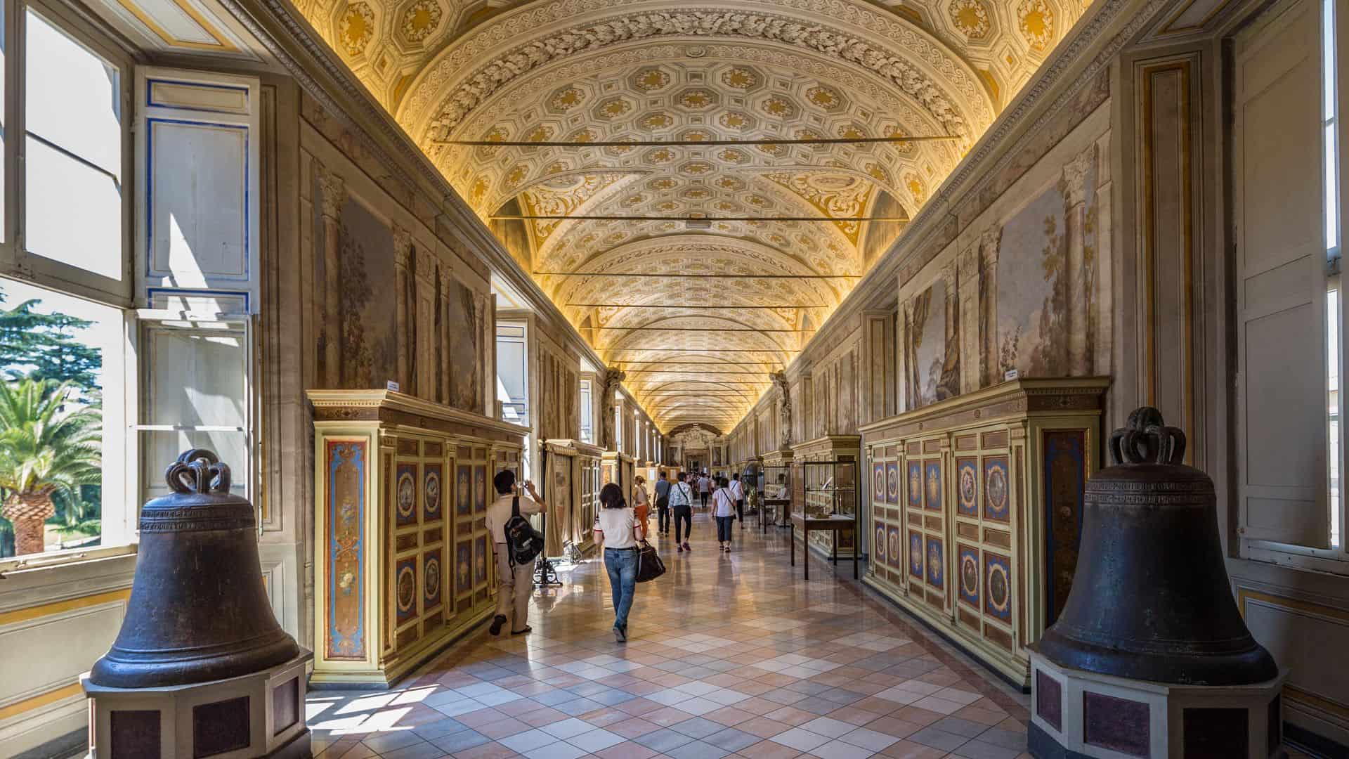 Long corridor with visitors walking around in the Vatican Museums in Rome