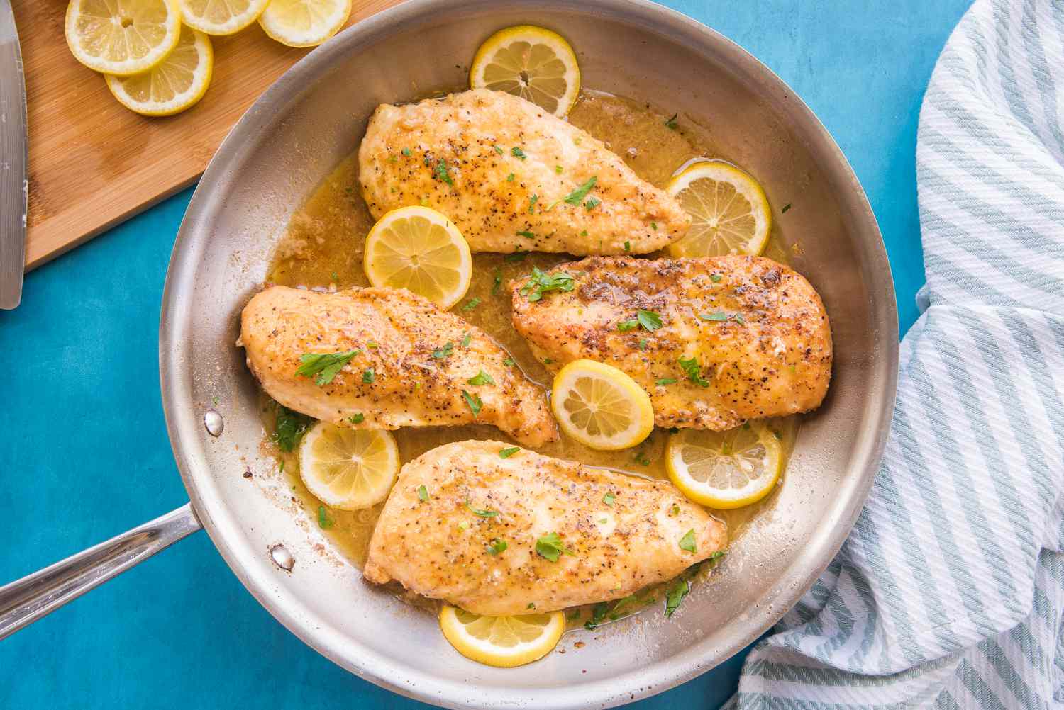 Lemon Pepper Chicken in a Pan Garnished with Shredded Parsley and Lemon Slices