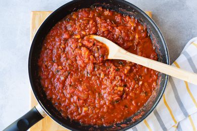 Homemade Tomato Sauce in a skillet with a wooden spoon