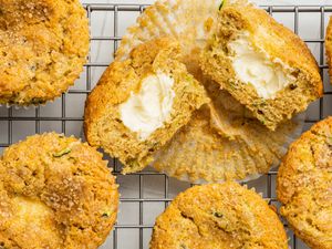 Cream Cheese Zucchini Muffins With One Cut in Half, All on a Cooling Rack