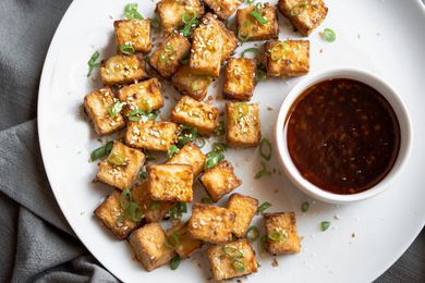 Crispy Air Fryer Tofu on a Plate Served with a Bowl of Sauce