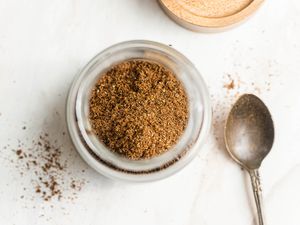 Jar of Garam Masala Next to a Spoon and Jar Lid