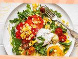 Plate of salad with tomatoes, burrata, corn, and arugula