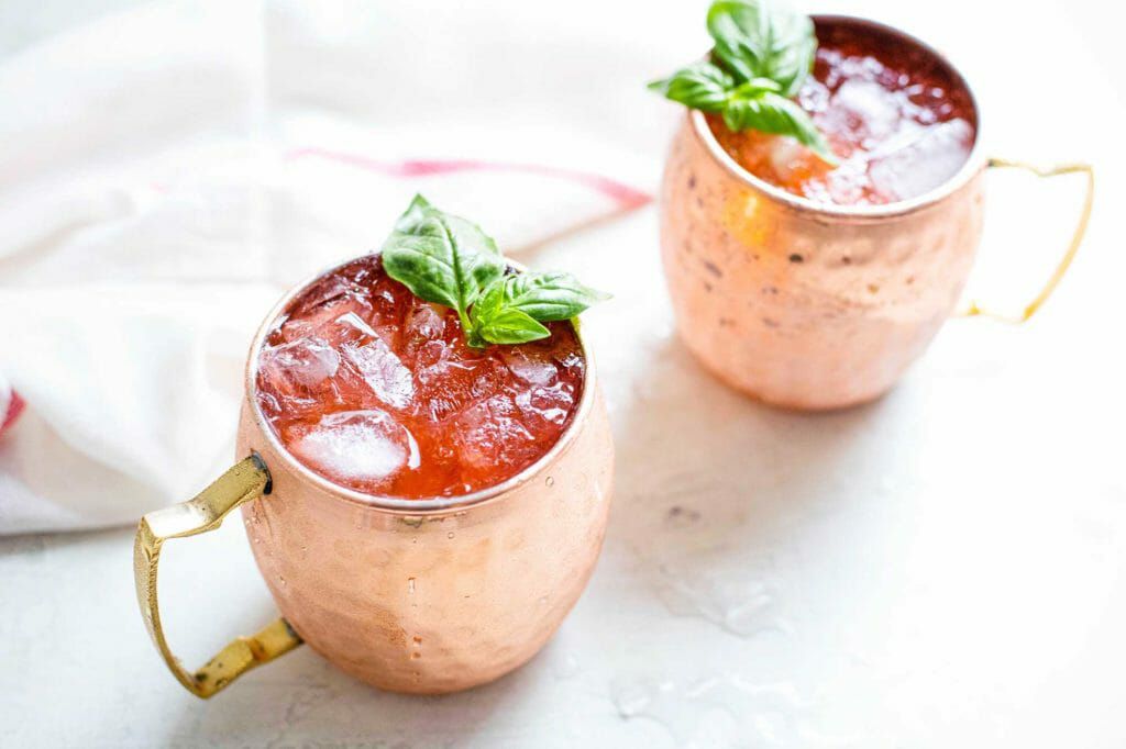 Moscow Mule Variation with Strawberry two moscow mules in copper mugs with basil garnish