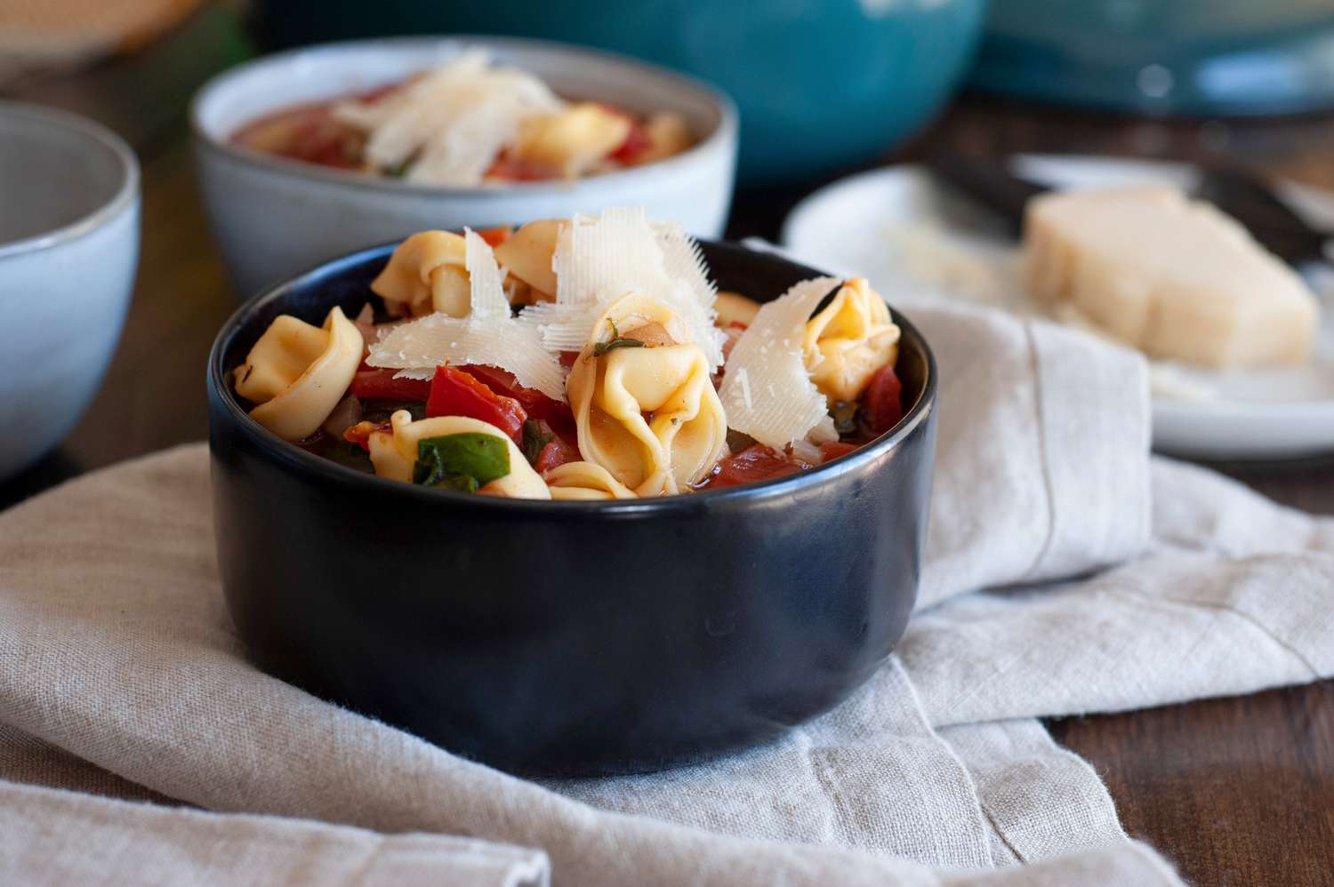 Side view of two bowls of cheese tortellini soup.