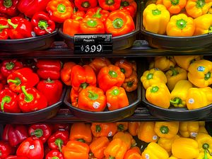 red, orange, and yellow bell peppers on store shelves