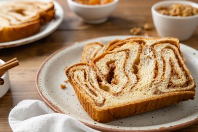 Slices of Povitica on a Plate Surrounded by Small Bowls of Ingredients (Pecans, Cinnamon, etc)