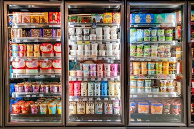 A grocery store freezer aisle with cartons of ice cream