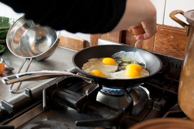 Person cooking eggs in a nonstick skillet