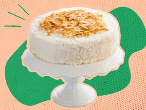 coconut cake on a cake stand (photo cut out) over a green and peach background 
