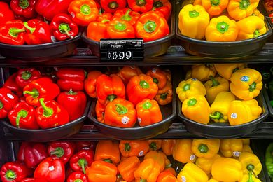 red, orange, and yellow bell peppers on store shelves