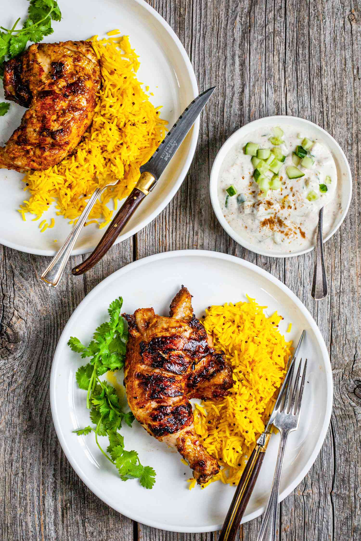 Tandoori Chicken with Turmeric Rice on Plate Next to Bowl of Raita