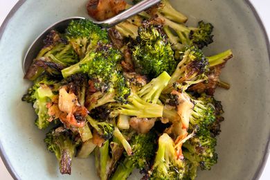 Cheesy Broccoli in a neutral bowl with a spoon