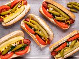 Overhead view of a sheet pan with Chicago-style hot dogs on it.