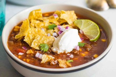 A bowl of crockpot Taco Soup topped with sour cream and chips