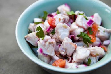 Ceviche with fish, onion, tomatoes, and chilis in a bowl