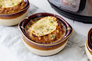 Bowl of French Onion Soup with crusty bread and melted cheese on top with an Instant Pot in the background.