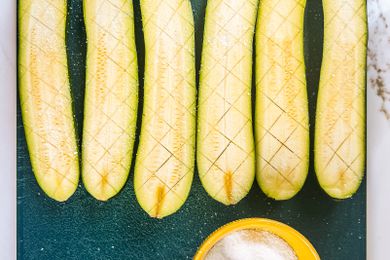 Halved and salted zucchini on a cutting board