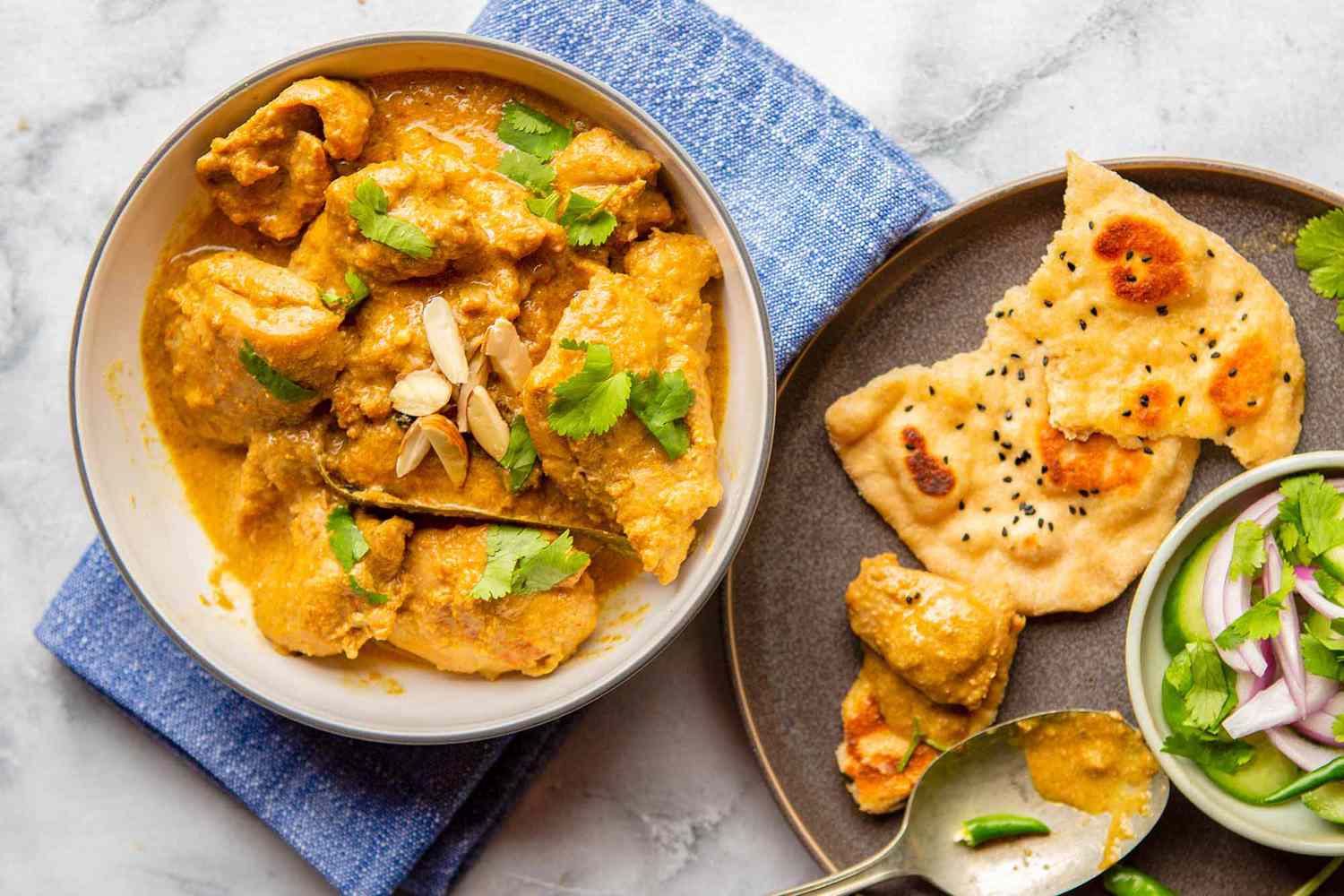 Best Recipe for Chicken Korma - bowl of chicken korma with plate of Naan