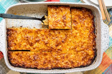 Casserole Dish of Trinidadian Macaroni Pie Cut into Individual Servings with One Piece Lifted Using a Spatula