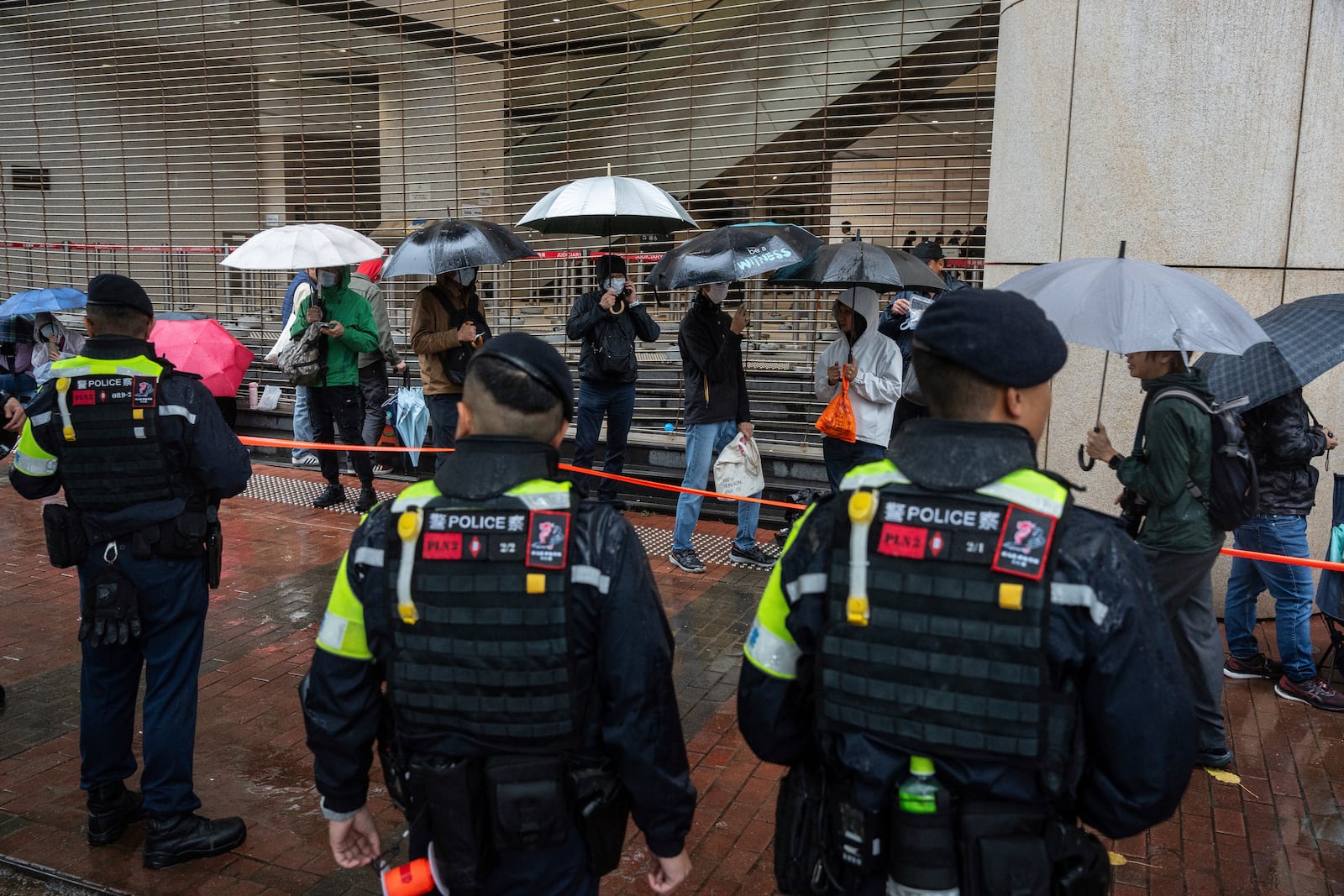 People wait to enter the West Kowloon Magistrates' Courts in Hong Kong, Wednesday, Nov. 20, 2024, ahead of Hong Kong activist publisher Jimmy Lai's national security trial. (AP Photo/Chan Long Hei)