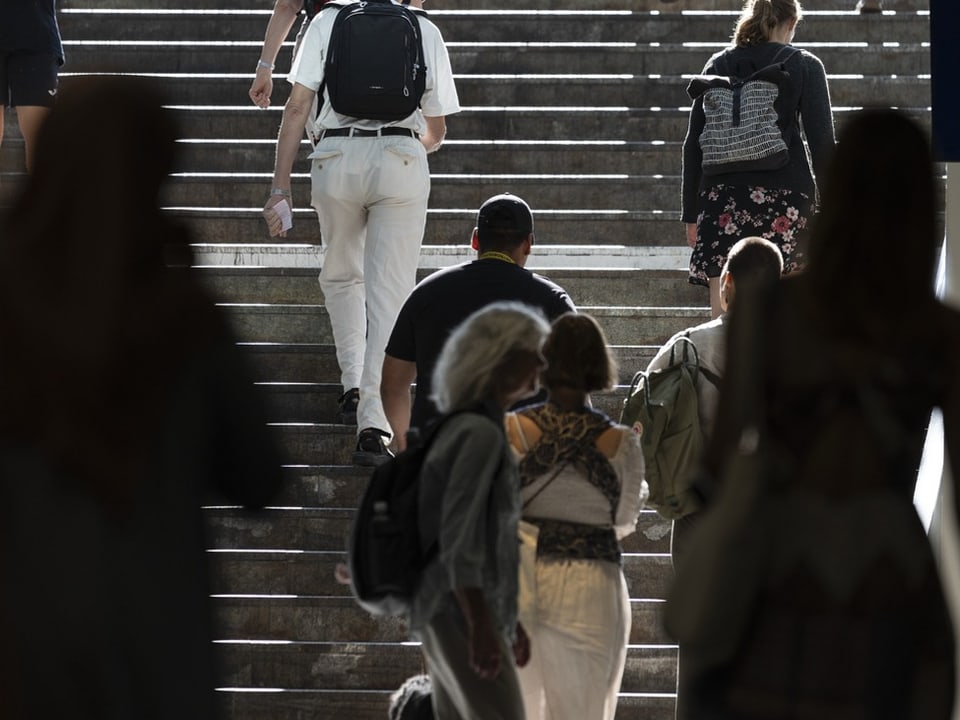 Menschen steigen eine Treppe hinauf.