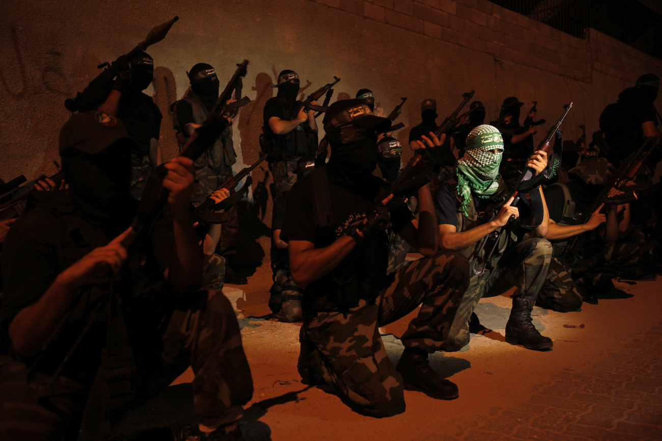 Masked Palestinian members of the "Ezz Al-Din Al Qassam" militia, the military wing of Hamas, hold their weapons and pose for the media during a march on the streets of Gaza City, Wednesday, Sept. 4, 2013. Arabic on headband reads, "No God but Allah and Mohammed is his prophet, Ezz Al-Din Al Qassam brigade." (AP Photo/Adel Hana)