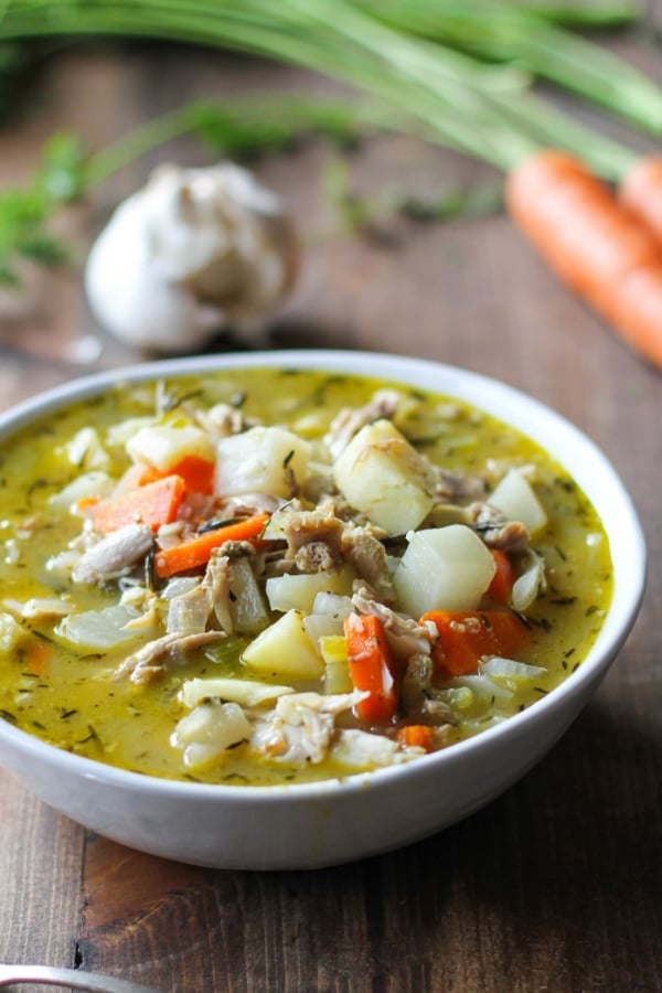 Close up white bowl of turkey soup with root vegetables