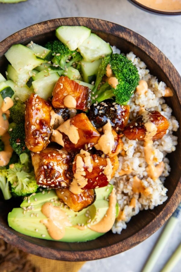 Wooden bowl of salmon bites and veggies.