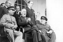 Black and white photo of Stalin, Roosevelt, and Churchill during the Tehran Conference.