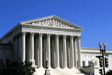 The classical columns of the Supreme Court Building set against a clear blue sky