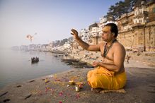 A Brahmin priest prays beside the Ganges River