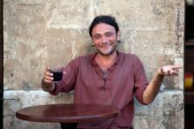 Italian man drinking wine at a sidewalk cafe