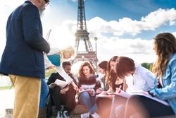 students and teacher in front of Eiffel tower