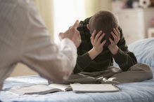 Father lecturing son in bedroom