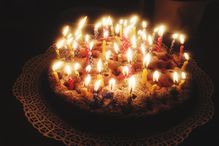 High Angle View Of Lit Candles On Birthday Cake On Table