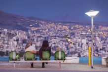 People sitting in Iran Park above the Iran, Tehran city skyline