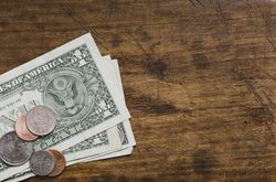 US currency, dollar bills with assorted coins