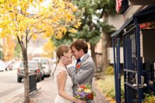 Bride and groom kissing on sidewalk