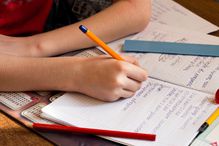 Cropped Image Of Boy Writing On Book