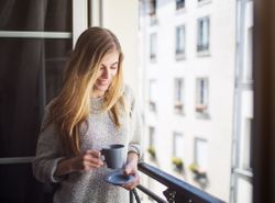 french woman drinking tea on balcony