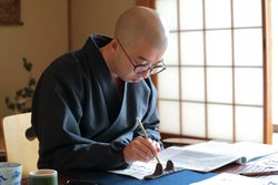 Man doing calligraphy in Japanese-style room