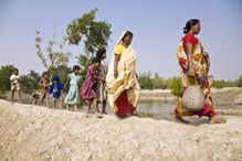 Families walk on elevated mud dykes