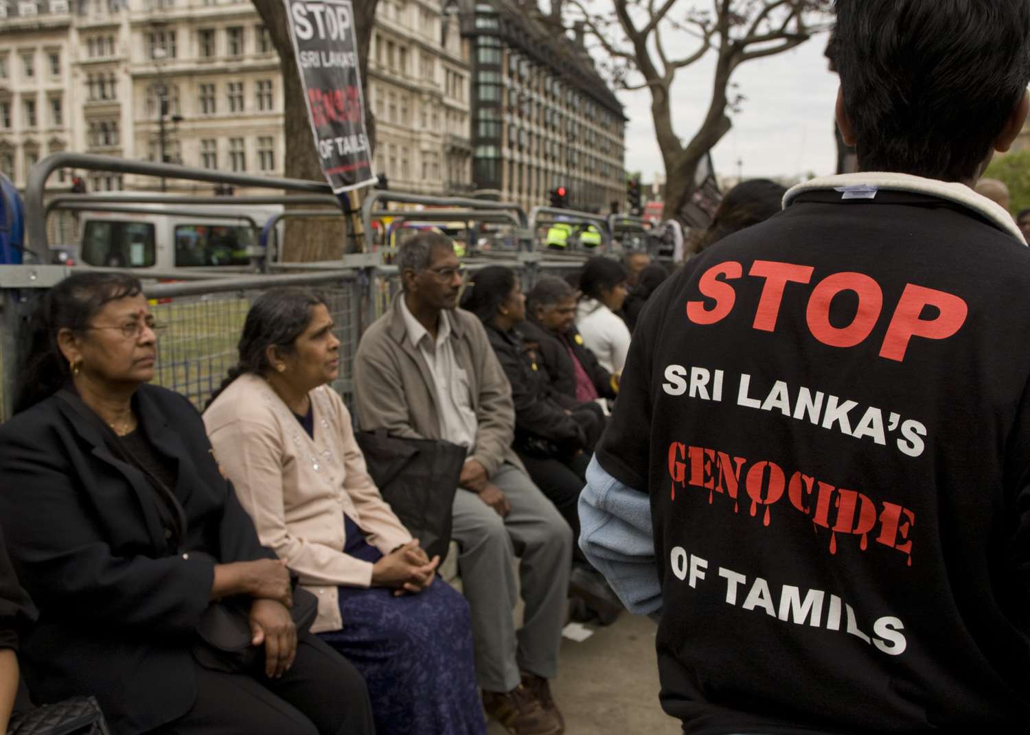 Man wearing anti-genocide shirt among protesters in London.