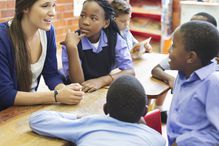 Woman speaking to young students in classroom