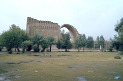 The Sassanian Arch behind a line of trees.