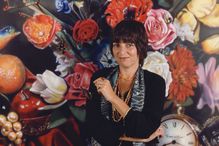 Audrey Flack photographed against a floral painting